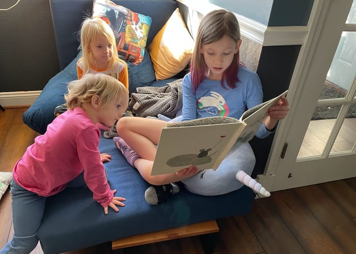 Adult reading aloud to children in a cozy setting