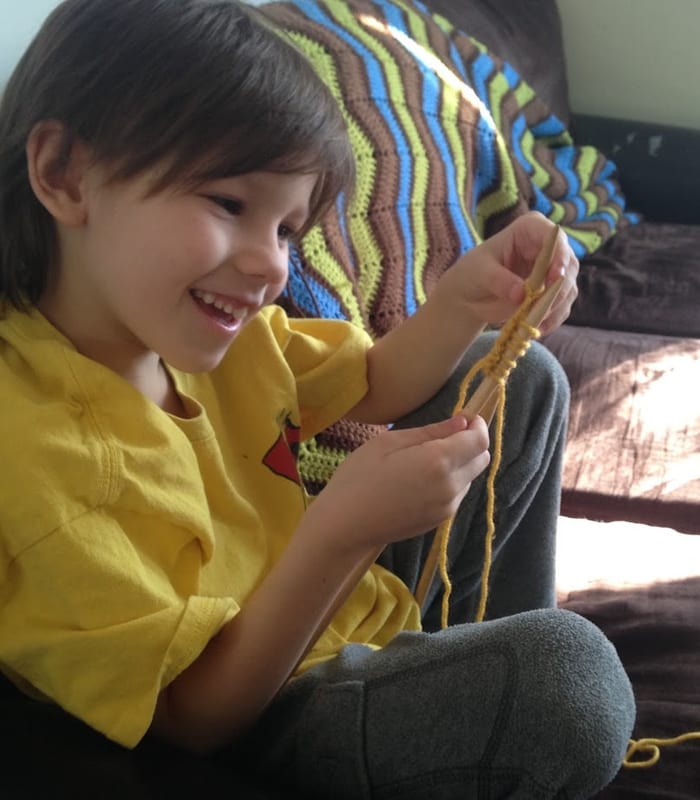 Hands working with yarn and knitting needles